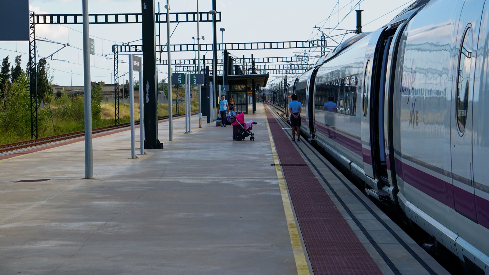 Passengers waiting beside a train at a station in Barcelona, Spain