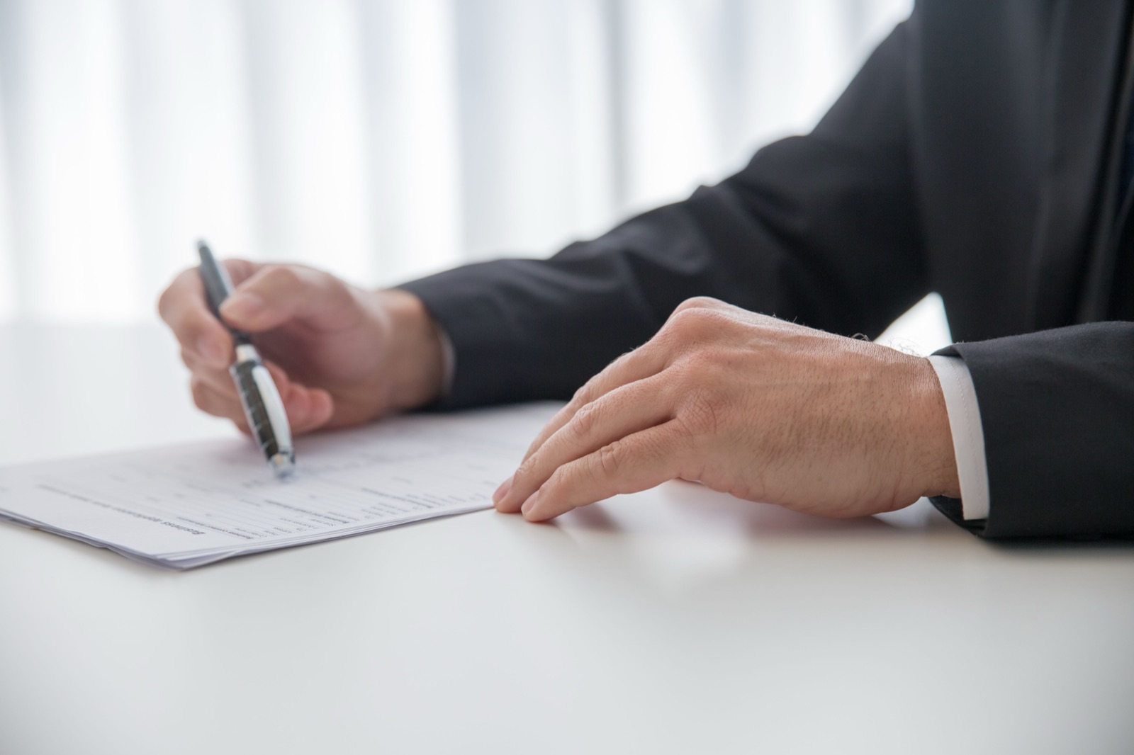 Hombre firmando documentos en un escritorio de oficina