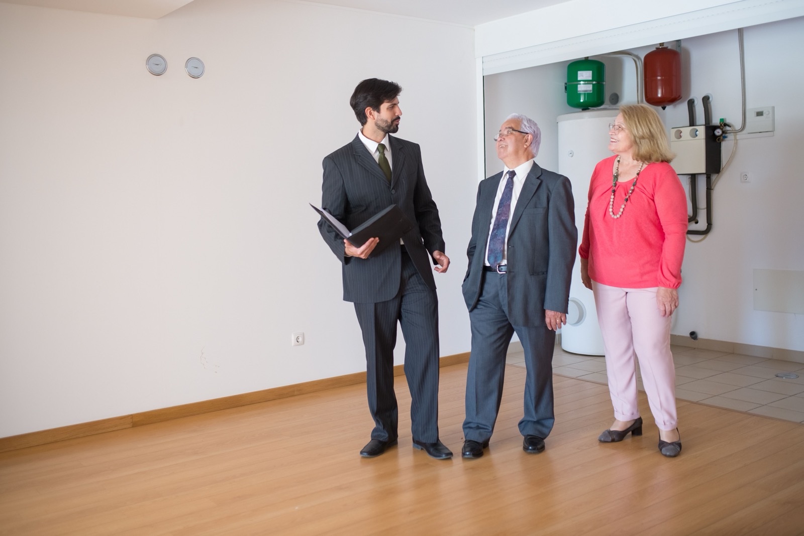 Personas visitando un piso vacío junto a un agente