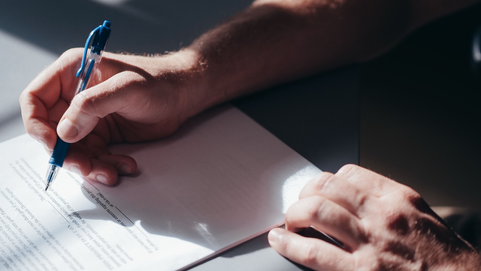 Persona firmando un documento legal