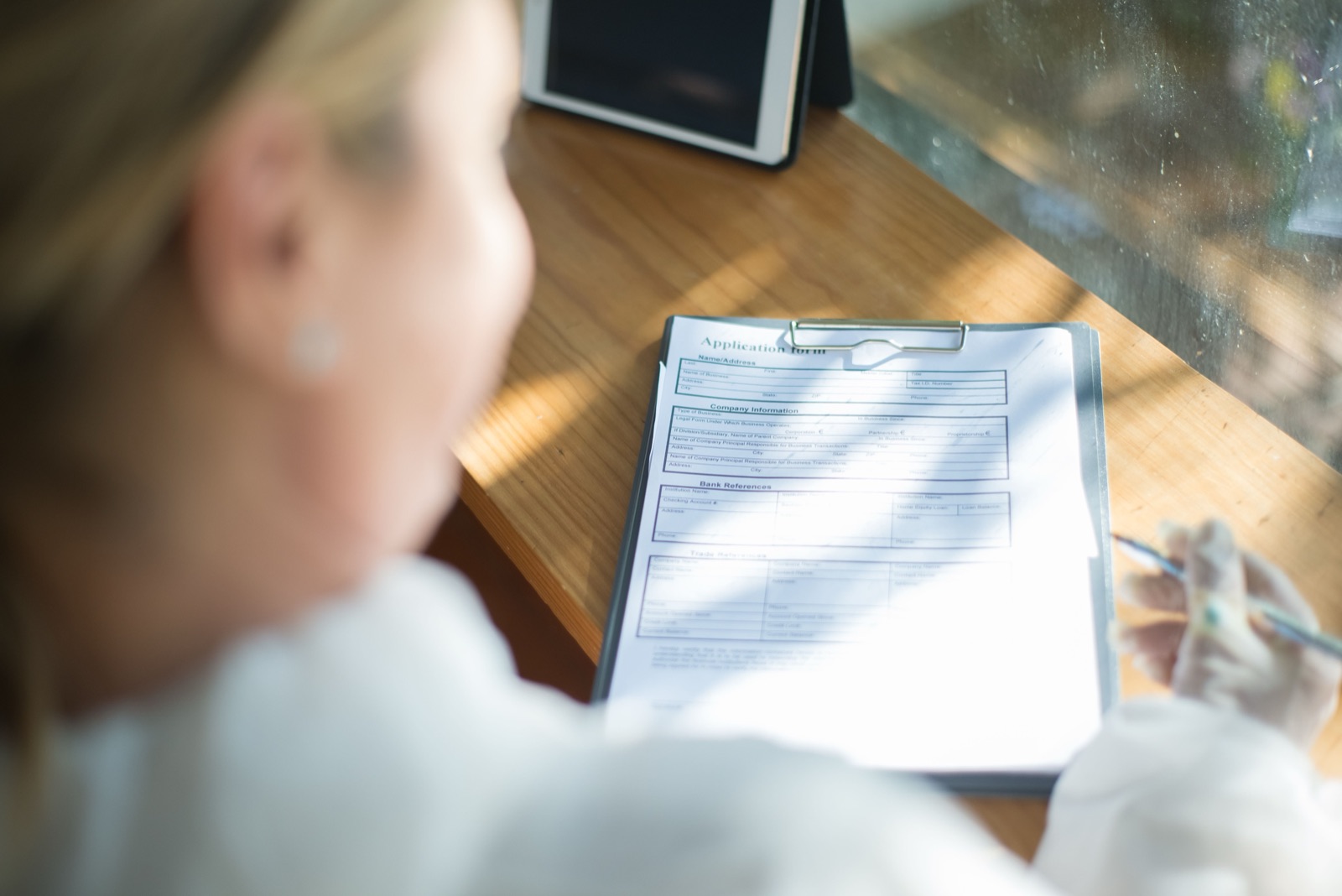 Filling out an application form on a clipboard at a desk