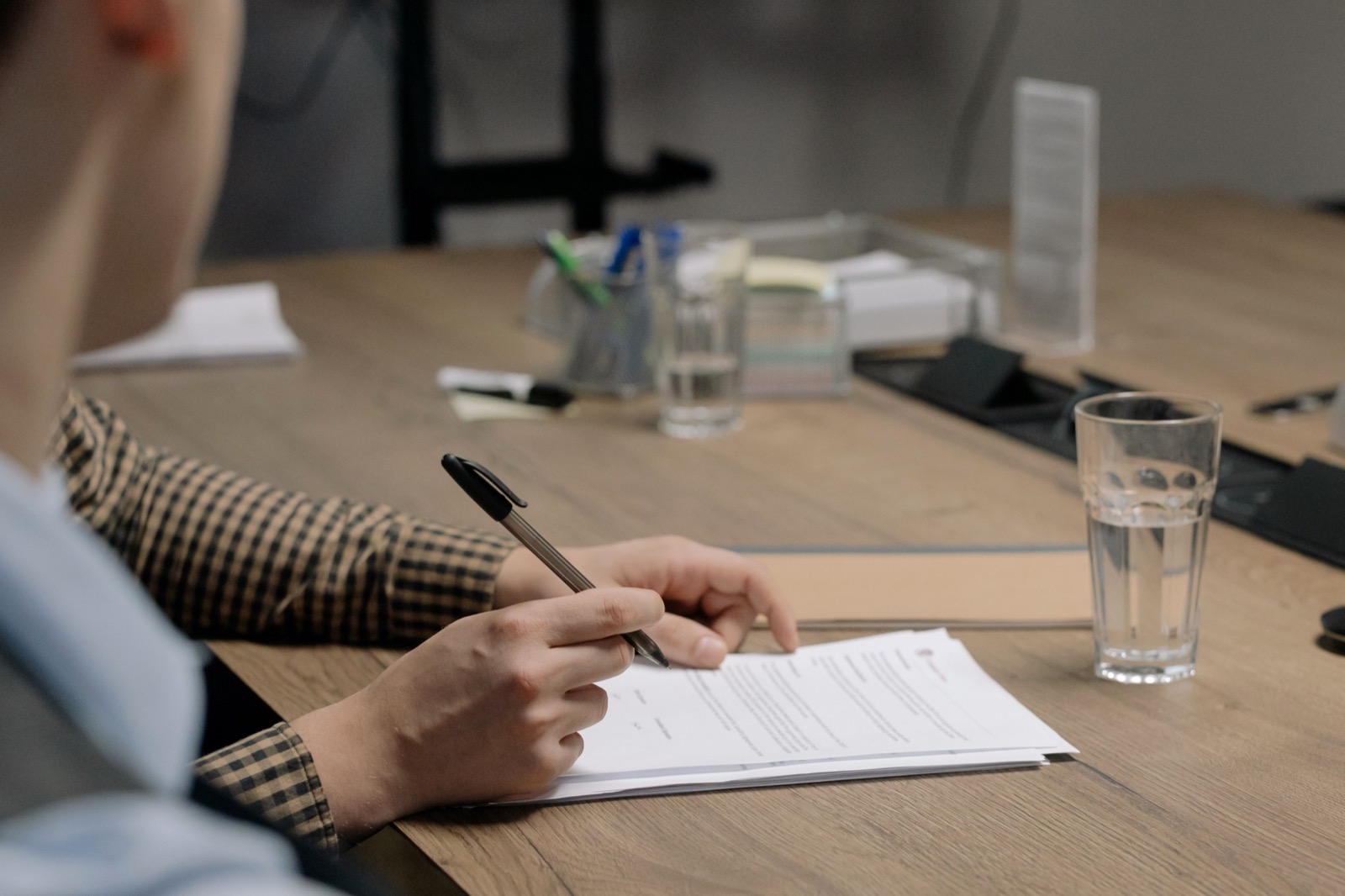 Persona firmando un documento en una oficina