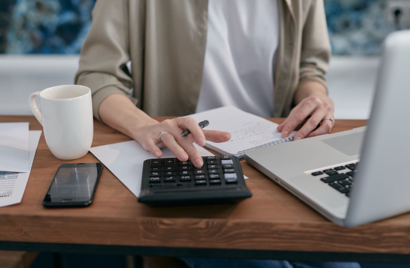 Persona usando una calculadora y un portátil