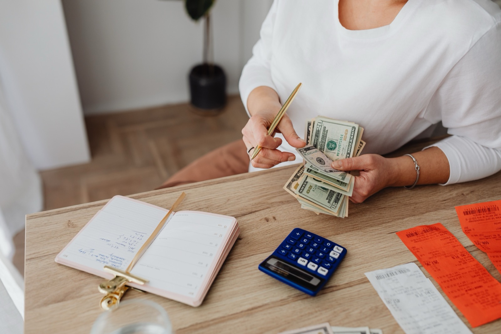Mujer calculando gastos con recibos y calculadora