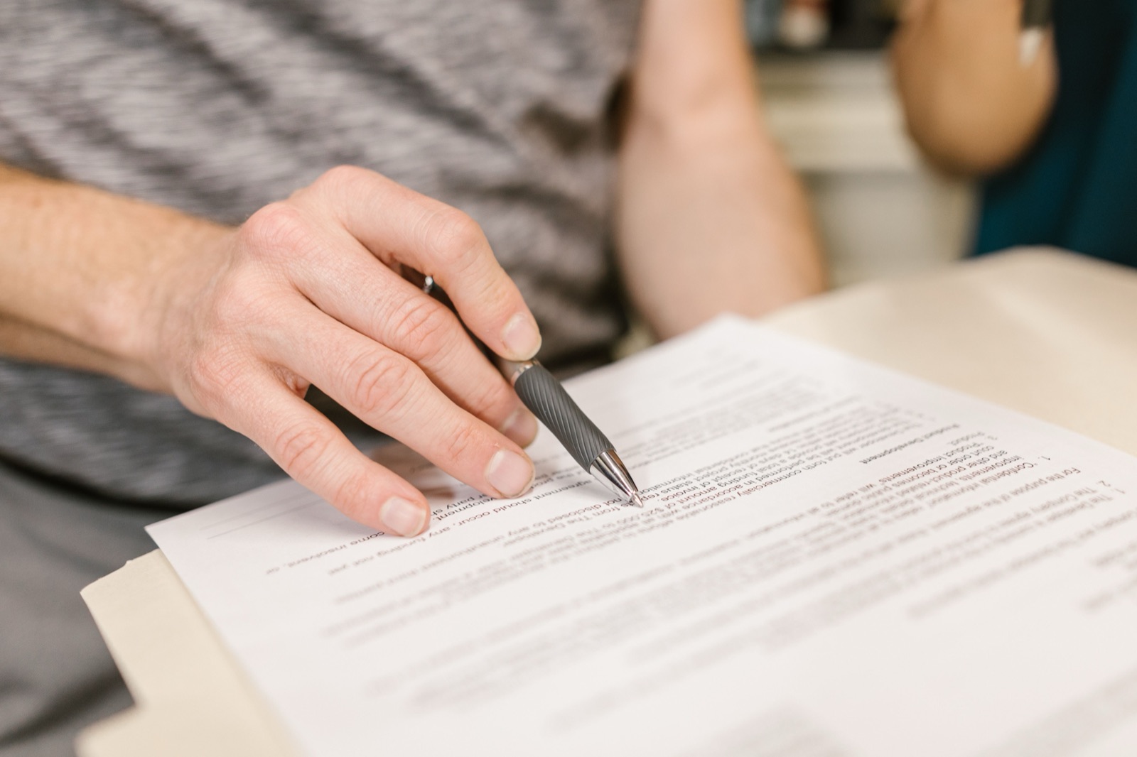 Hand signing a lease contract with a pen