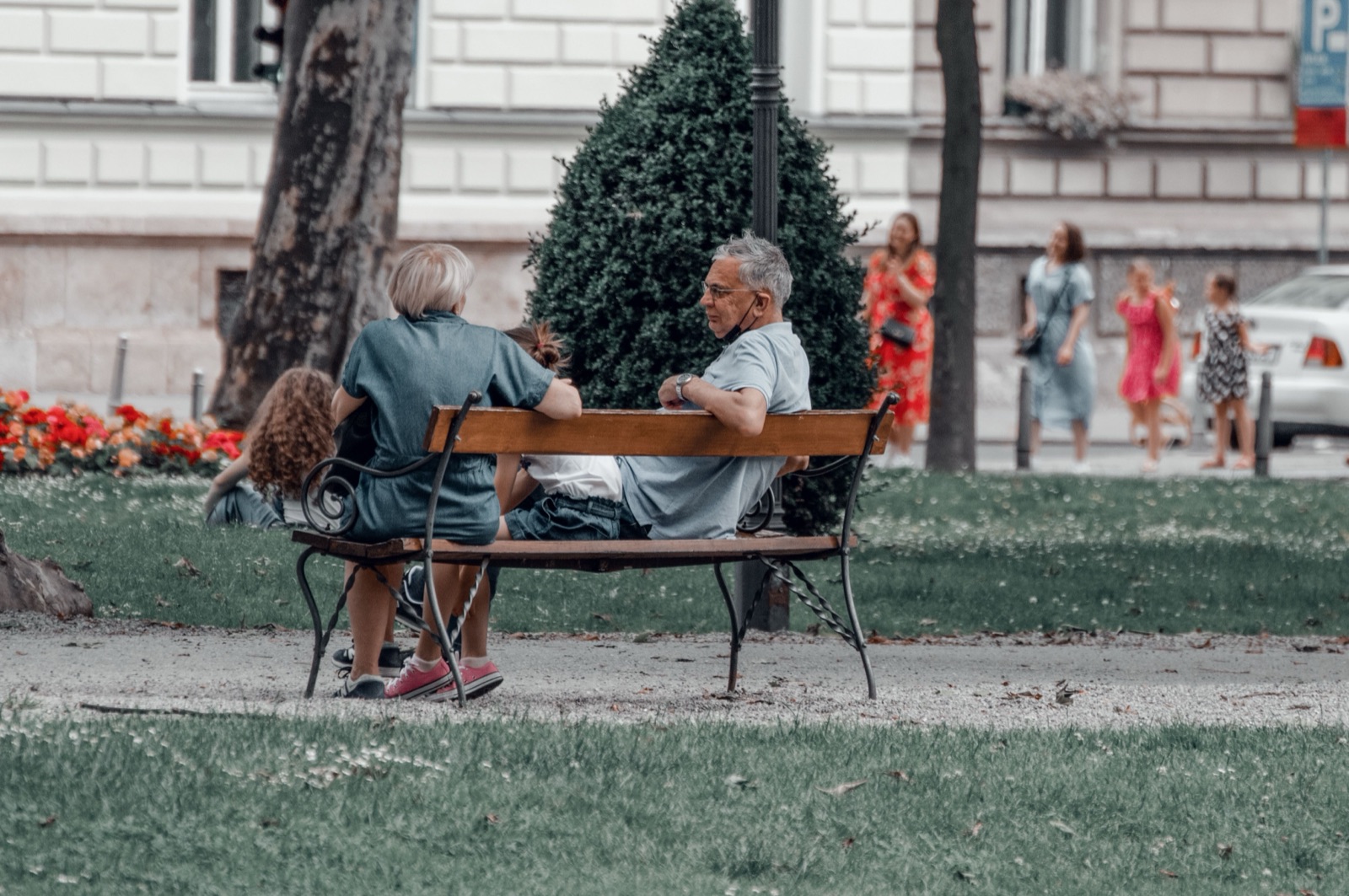 Family sitting together on a bench in a city park
